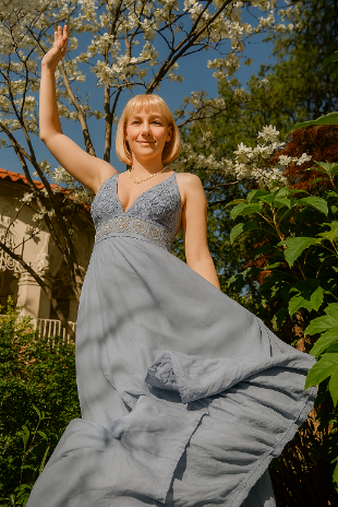 Jenni wearing a dress, near trees.